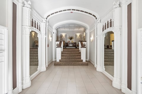A hallway with white walls and a staircase.