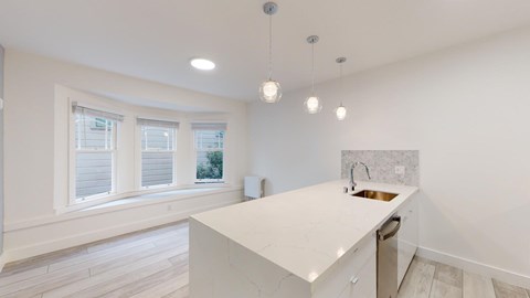 A kitchen with white cabinets and a white countertop.