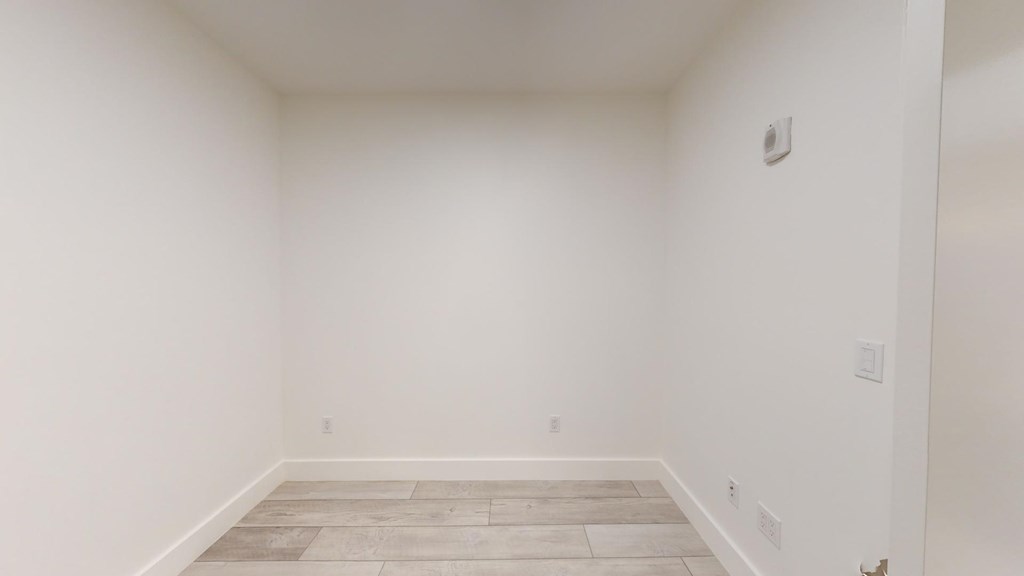 A room with a wooden floor and white walls.