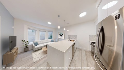 A modern kitchen with a stainless steel refrigerator and a white island.