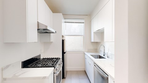A white kitchen with a stove top oven and a dishwasher.