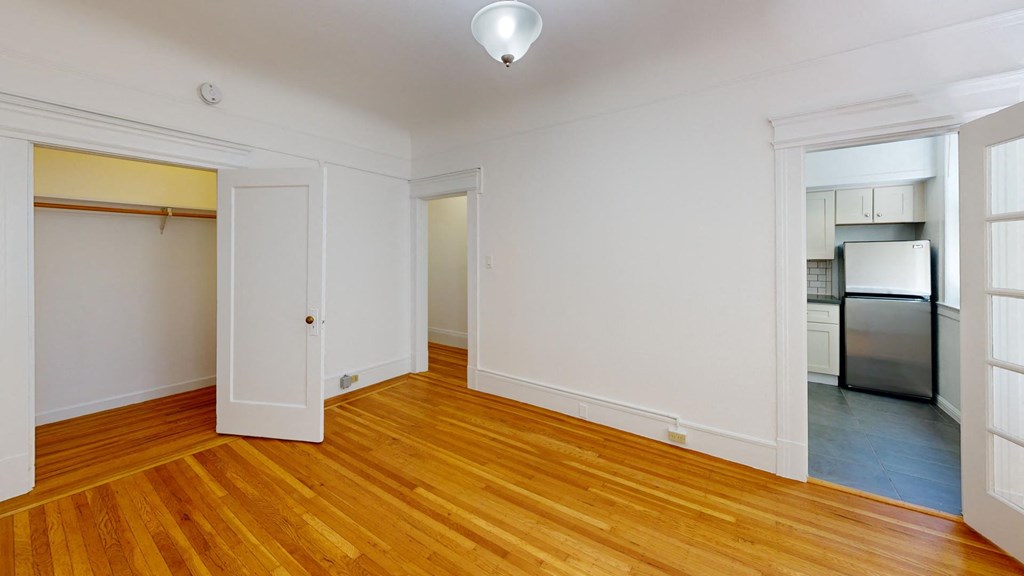 a living room with wood floors and white walls
