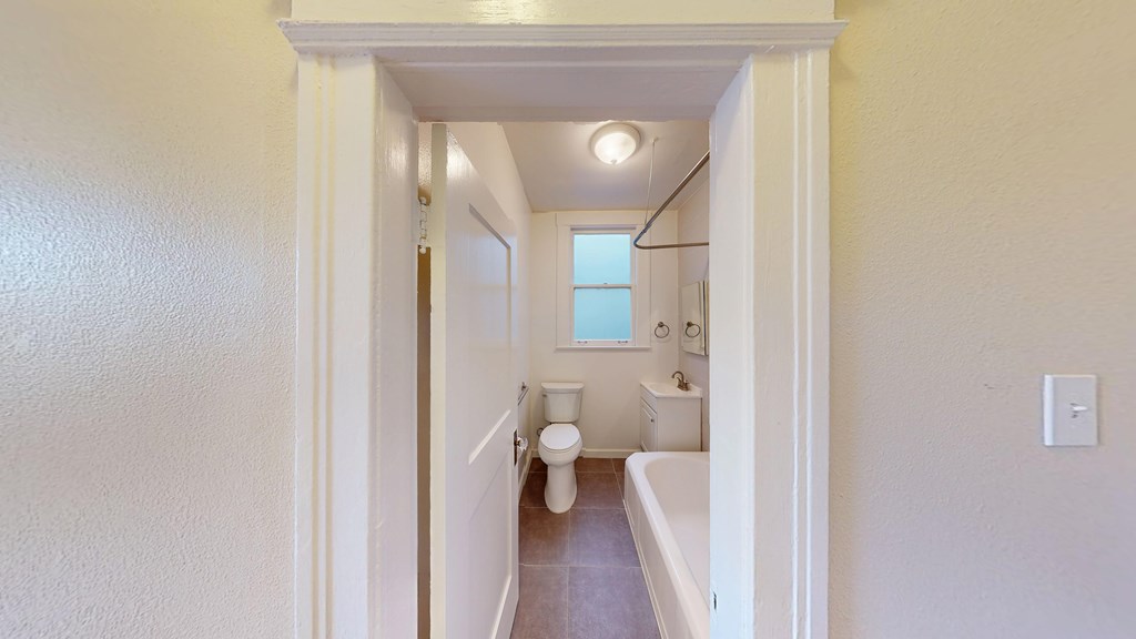 A white bathroom with a toilet, sink, and bathtub.