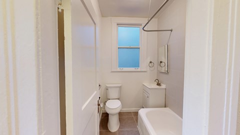 A small bathroom with a toilet, sink, and bathtub.