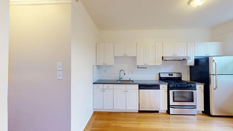 A kitchen with white cabinets and black appliances.