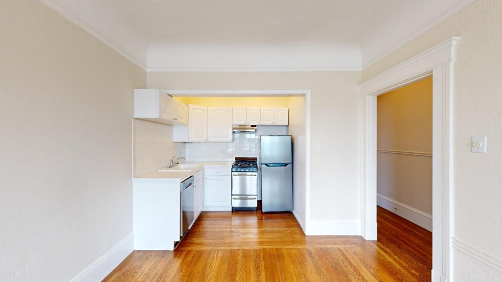 a renovated kitchen with white cabinets and stainless steel appliances