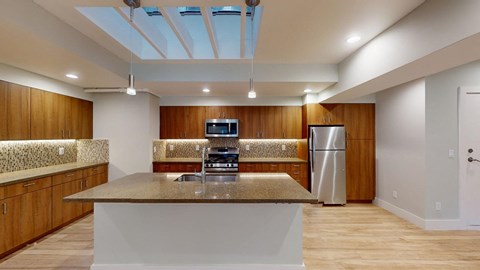 a kitchen with a counter top and a stainless steel refrigerator