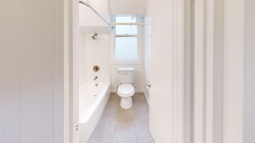 a white bathroom with a tub and a toilet
