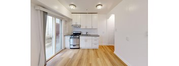 a kitchen with white cabinets and a sliding glass door