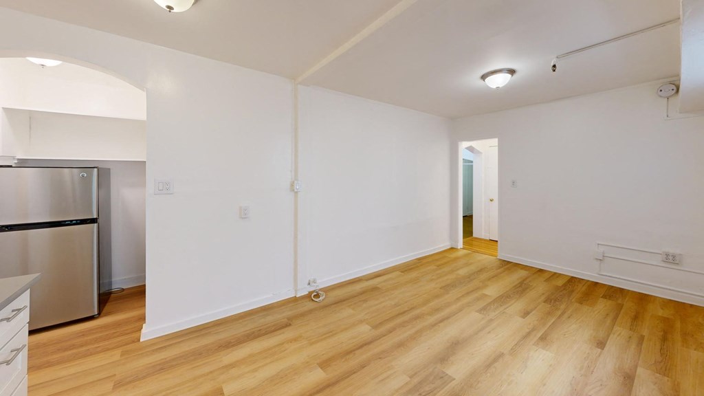 a renovated living room and kitchen with wood floors and white walls