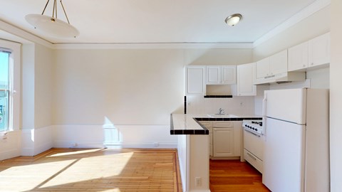 A kitchen with white appliances and cabinets.