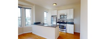 a kitchen with an island and a stove and a window