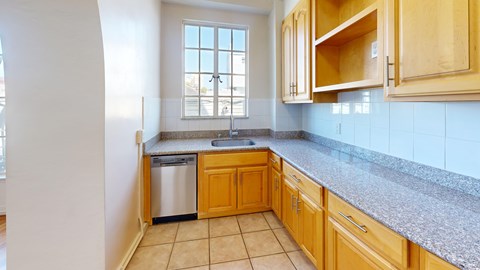 A kitchen with wooden cabinets and a granite countertop.