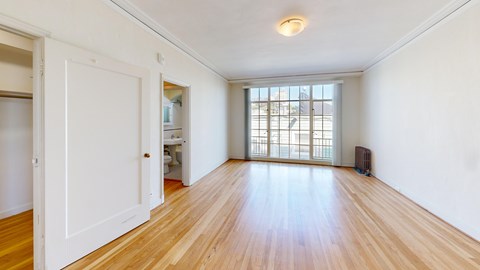 A room with wooden floors and a large window.
