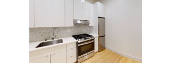 a kitchen with white cabinets and stainless steel appliances and a sink