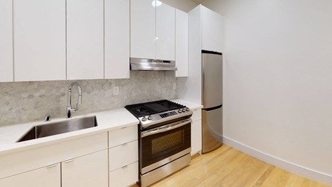 a kitchen with white cabinets and stainless steel appliances and a sink