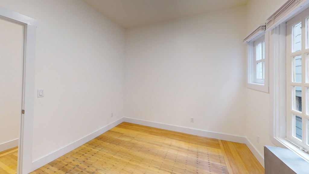 a living room with white walls and a wood floor