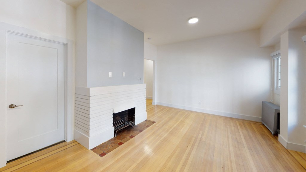 a living room with a fireplace and a wooden floor