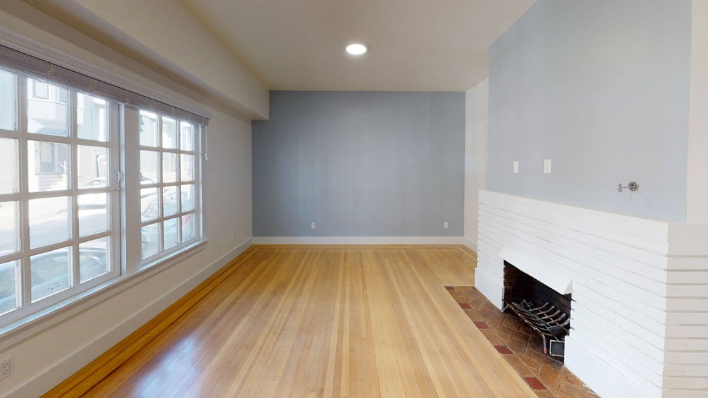 a living room with a fireplace and wooden floors