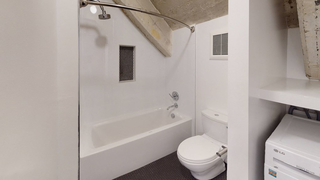 a bathroom with a toilet and a bath tub