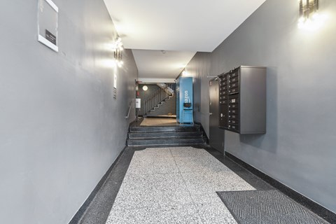 A hallway with a staircase and a blue door.