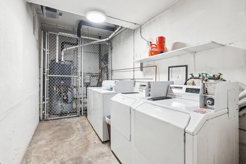 Laundry room with a row of washing machines and dryers