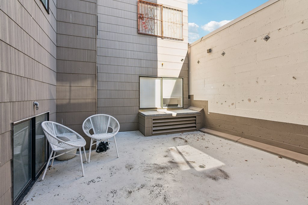 Enclosed outdoor patio area with round chairs