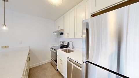 A kitchen with white appliances and cabinets.
