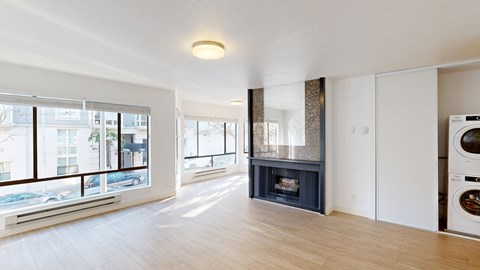 A modern living room with a fireplace and a washing machine in the corner.