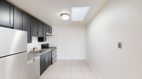 A kitchen with a refrigerator, sink, and oven.
