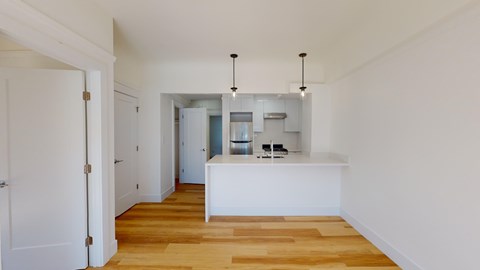 A kitchen area with a white counter and cabinets.