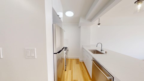 A white kitchen with a sink and a door.