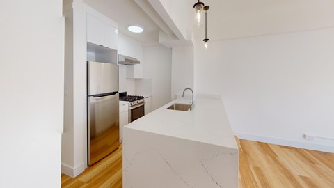 A kitchen with a white countertop and stainless steel appliances.