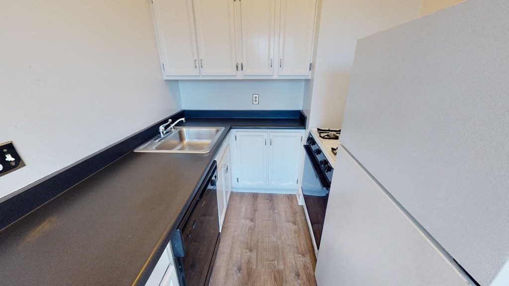a small kitchen with white cabinets and a sink
