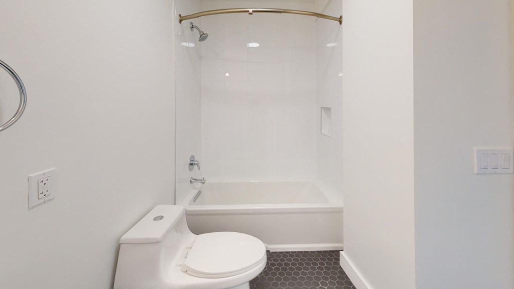 a white bathroom with a toilet and a tub