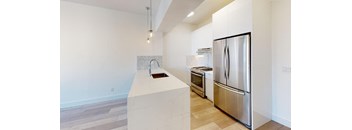 a white kitchen with stainless steel appliances and a large island
