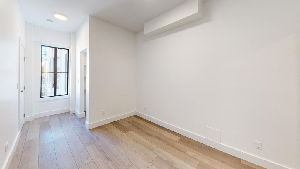 a living room with white walls and wood floors