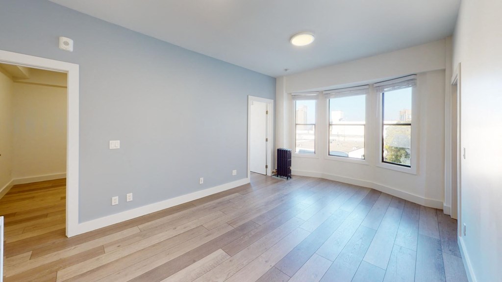 a living room with wood floors and a large window