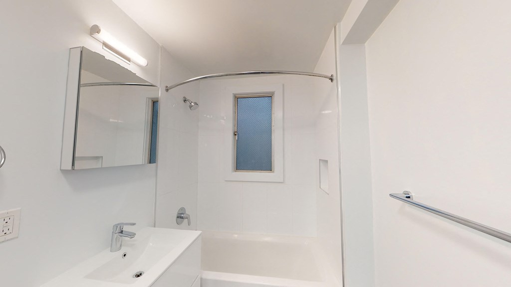 a bathroom with a tub and a sink and a mirror