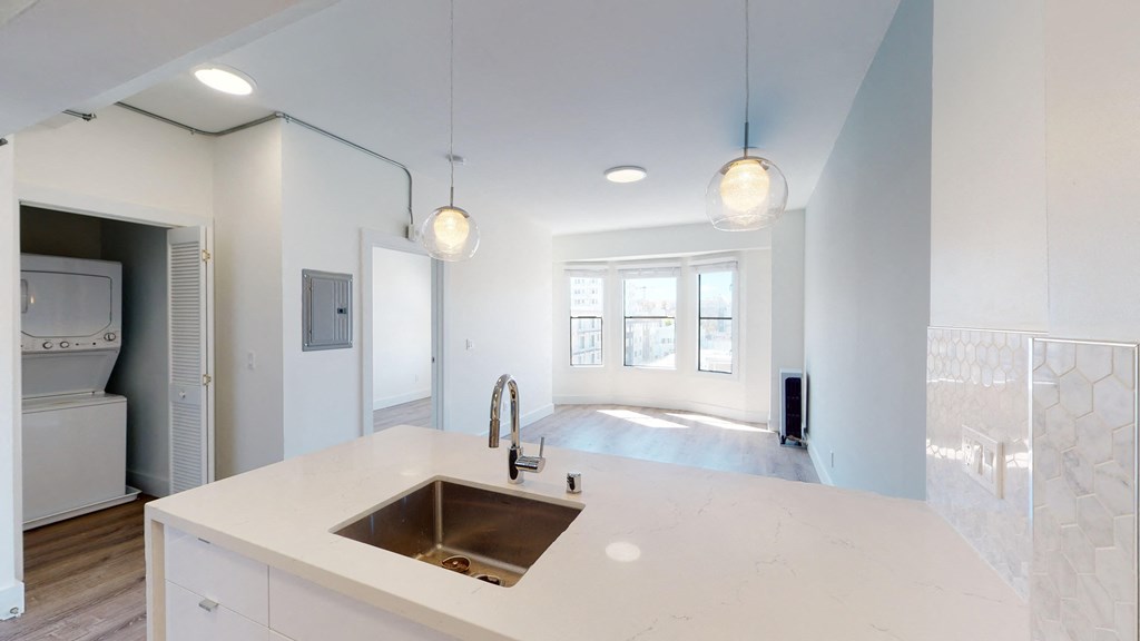 a white kitchen with a sink and a large window