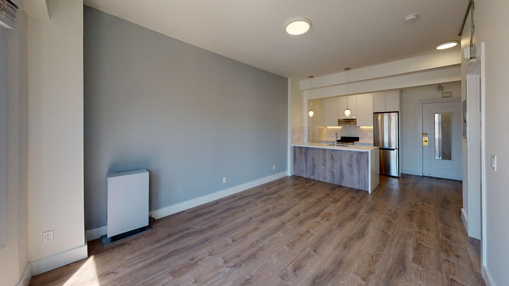 a kitchen and living room with wood flooring and blue walls