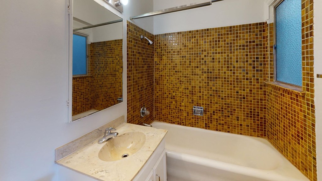 a bathroom with a tub and a sink and a mirror