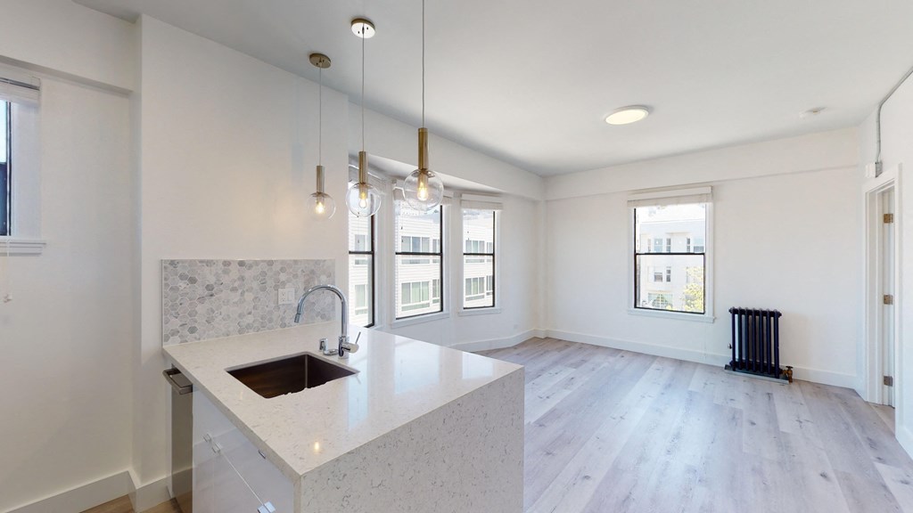 a kitchen with white walls and a large island with a sink