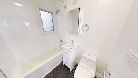 A white bathroom with a toilet, sink, and bathtub.