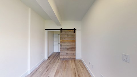 A long hallway with a wooden staircase.