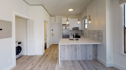 a kitchen with a white counter top and a washing machine