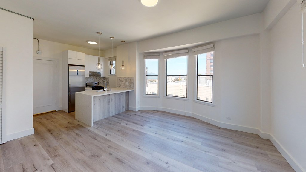 a living room with a kitchen and a large window