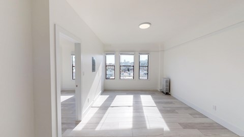 A spacious room with a long hallway leading to a window.