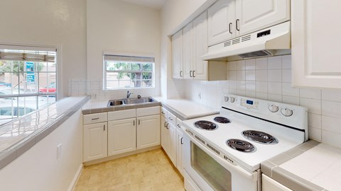 a white kitchen with white appliances and white cabinets