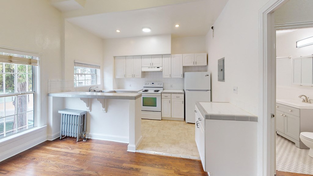 a kitchen with white cabinets and white appliances and a sink
